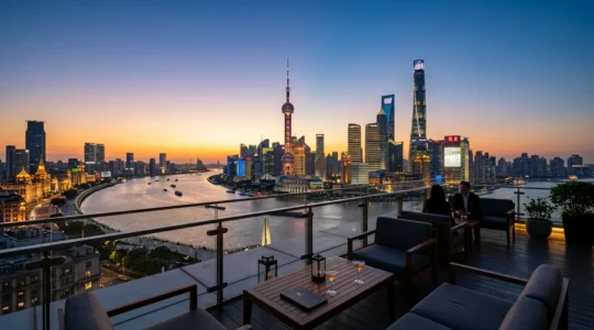 Vue panoramique d'un rooftop de Shanghai au crépuscule avec vue sur le Bund et les gratte-ciel de Pudong illuminés