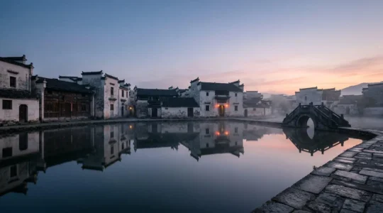 Village traditionnel de Hongcun dans la brume matinale avec ses maisons blanches et toits noirs reflétés dans l'étang de la Lune