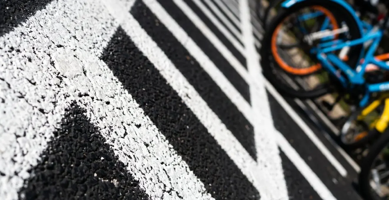 Vue aérienne d'une zone de stationnement délimitée par des lignes blanches avec vélos partagés correctement rangés